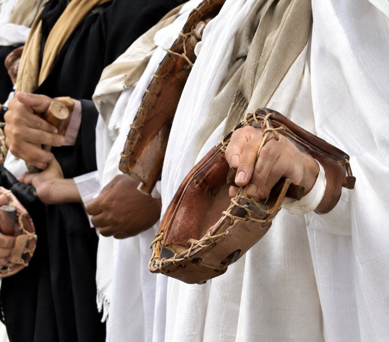 أيدي رجال تحمل الدفوف التراثية